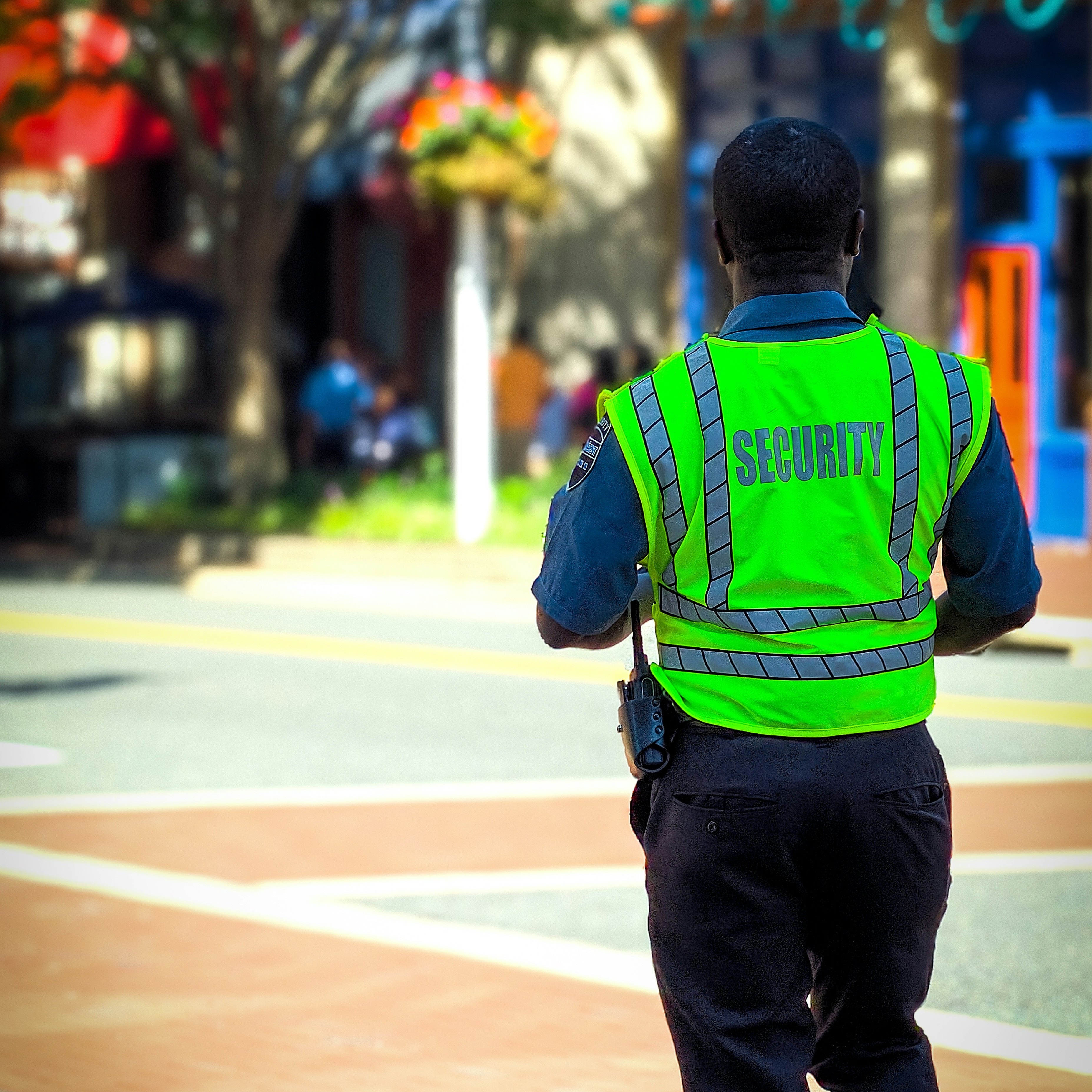 Security camera mounted on a ceiling with exit sign.