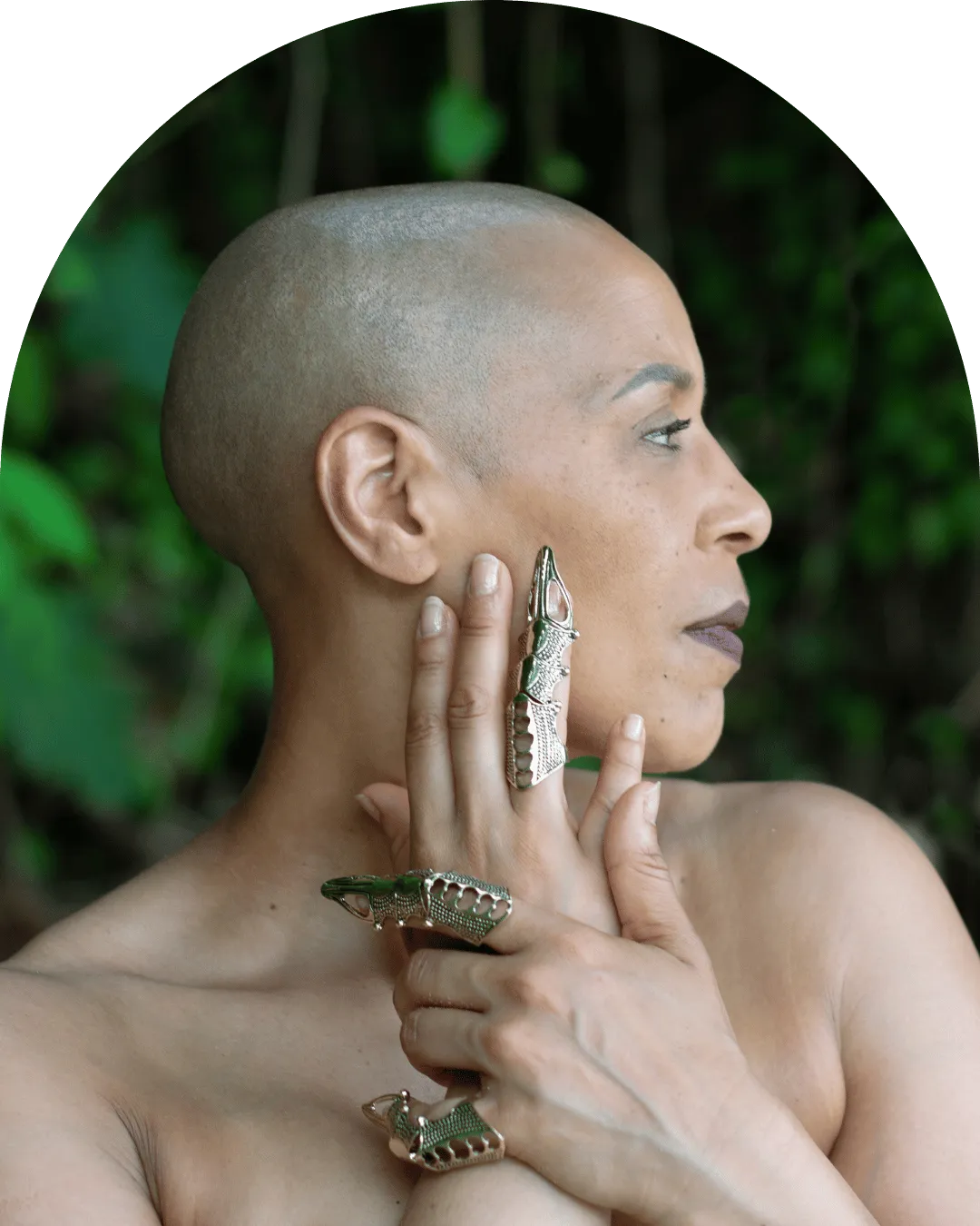 Portrait of a Kundalini facilitator seated in a gentle meditative pose with hands at heart, in soft linen robes.