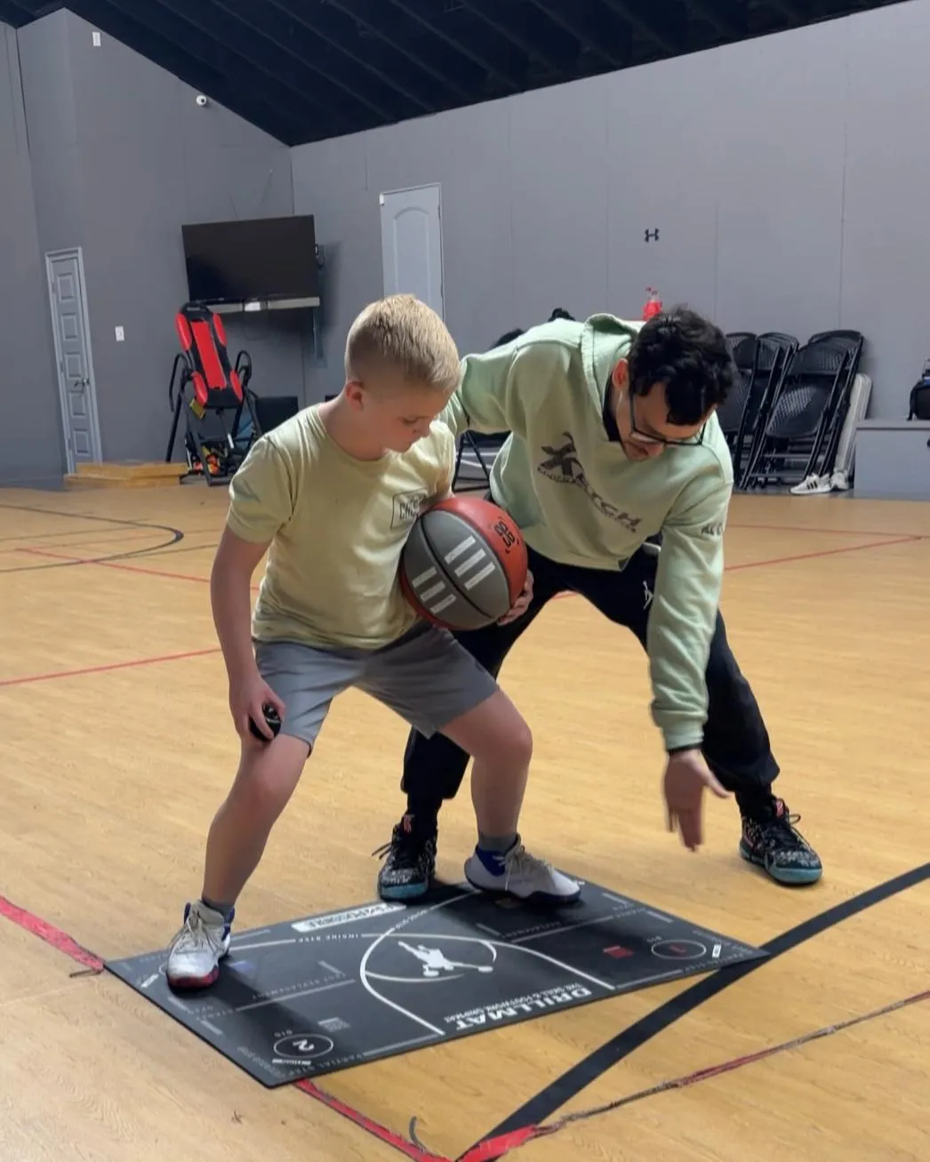 Coach instructing basketball player during drills