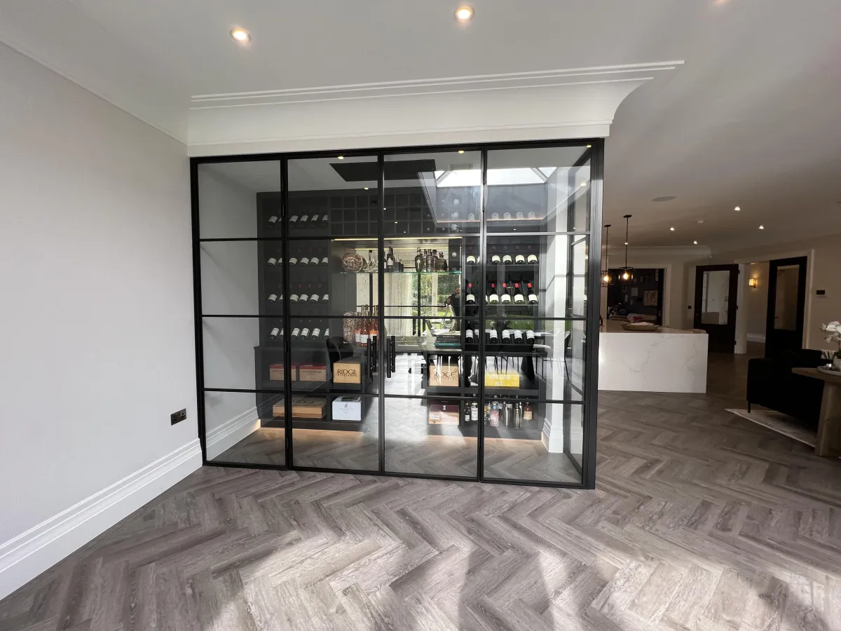 Wide black-framed glass wall and double doors enclosing a contemporary wine display room. | Creoglass