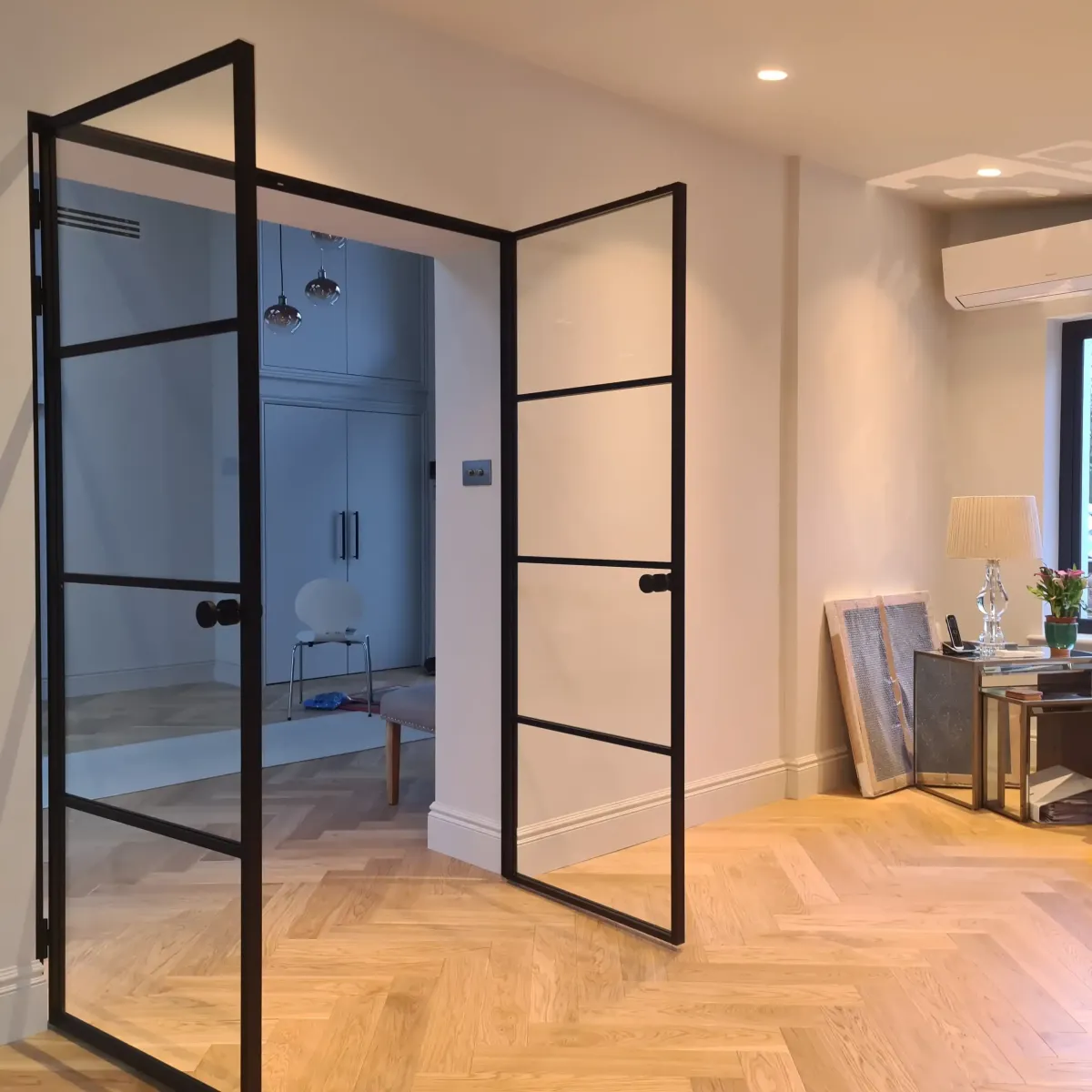Crittall style internal double doors in black steel, glass partition doors, modern entryway, herringbone wood floor. | Creoglass