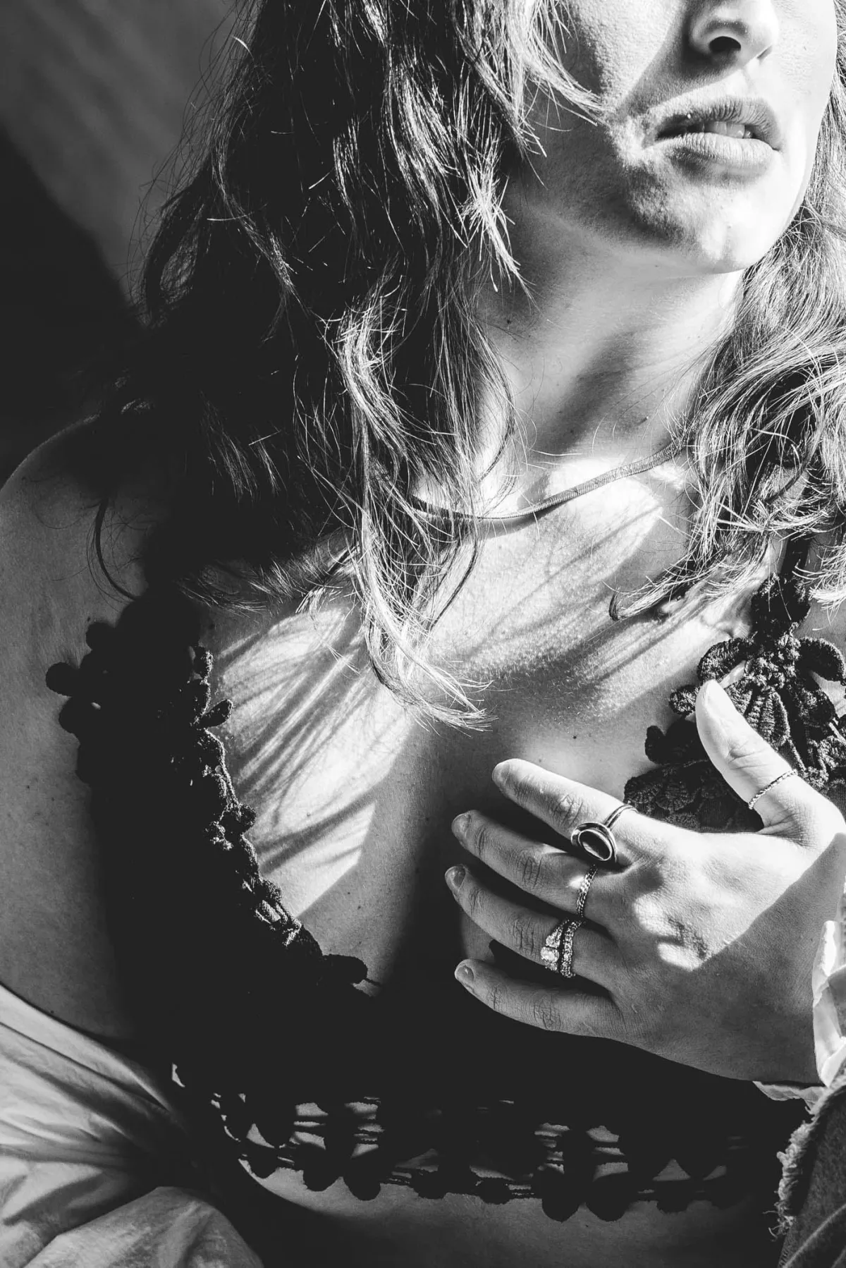 Grand Rapids bridal boudoir photography woman leaning on a white wall wearing her wedding veil showing off her engagement ring.