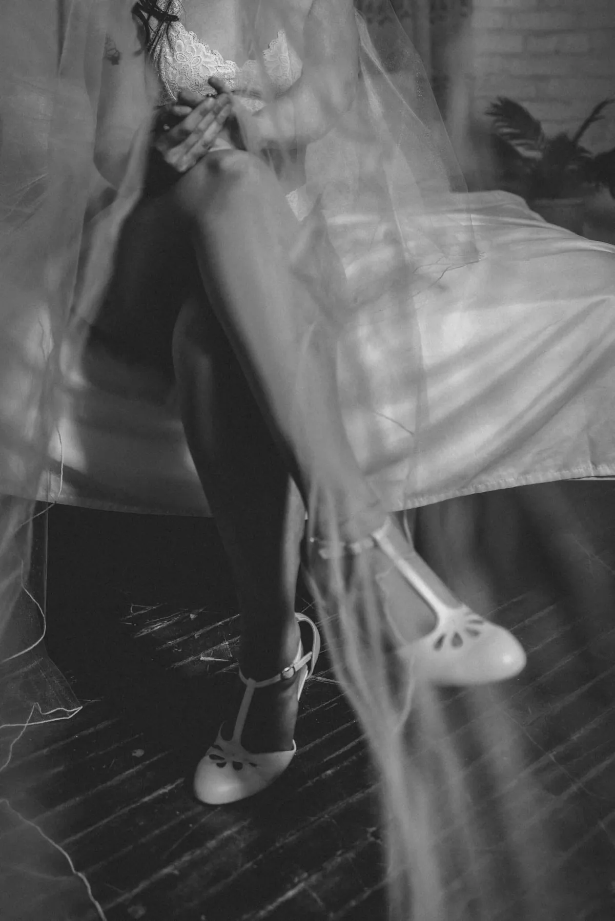 Grand Rapids black and white artistic boudoir photography. Bridal boudoir session; woman wearing a cathedral veil and her wedding shoes.