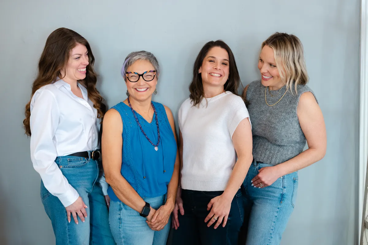 Four women laughing together at a SHEconnects event hosted by SHEsynergy. Photo by Molly Marie Photography