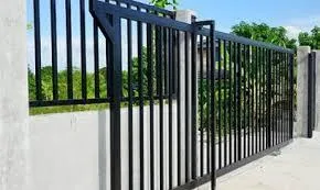 A driveway entrance with a sliding white ornamental gate