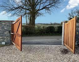 A driveway entrance with a sliding white ornamental gate