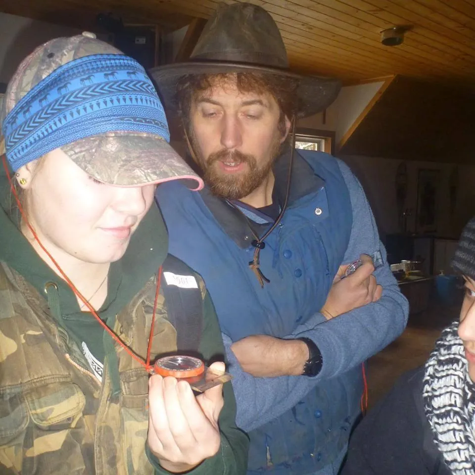 Outdoor education at the Off Grid Ark in Quebec, with students learning how to use a map and compass for navigation.