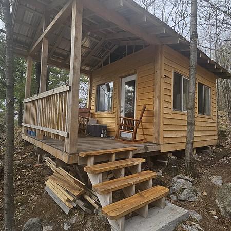 Cliffside Camp at the Off Grid Ark in Western Quebec, a private off-grid retreat with porch seating, forest views, and access to trails and lake.