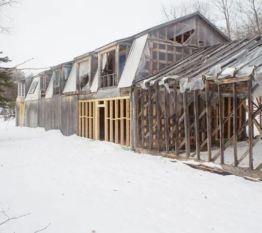 The Ark in 2002 as an abandoned sawmill with three walls, a roof, and exposed framing in winter.