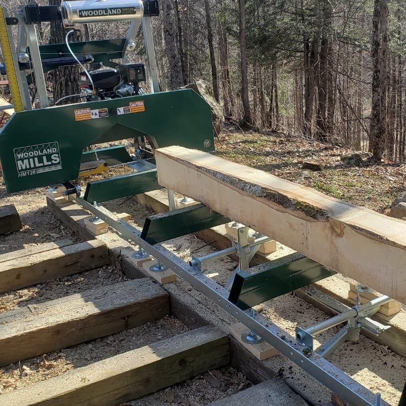 Portable sawmill cutting a log into lumber at the Off Grid Ark in Quebec, part of the sawmill and wood products program.
