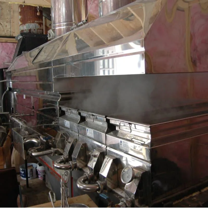 Wood-fired stainless steel maple syrup evaporator boiling sap at Off Grid Ark sugar shack in Quebec