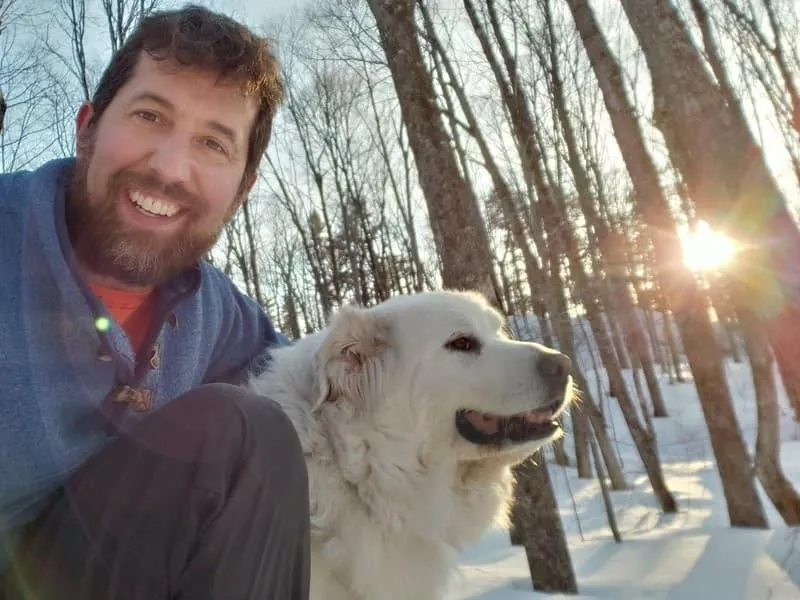 Mike Caldwell, founder of The Off Grid Ark, enjoying a winter day in the forest with his dog at his off-grid property in Western Quebec.