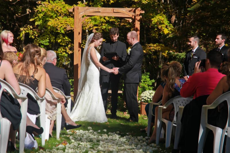 Outdoor wedding ceremony at The Off Grid Ark with guests seated among trees