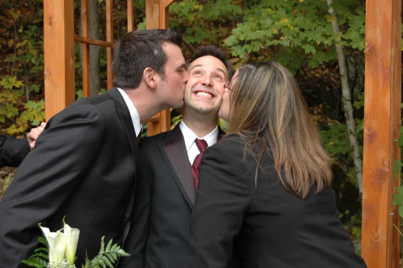 Wedding celebration moment with the groom surrounded by close family and friends