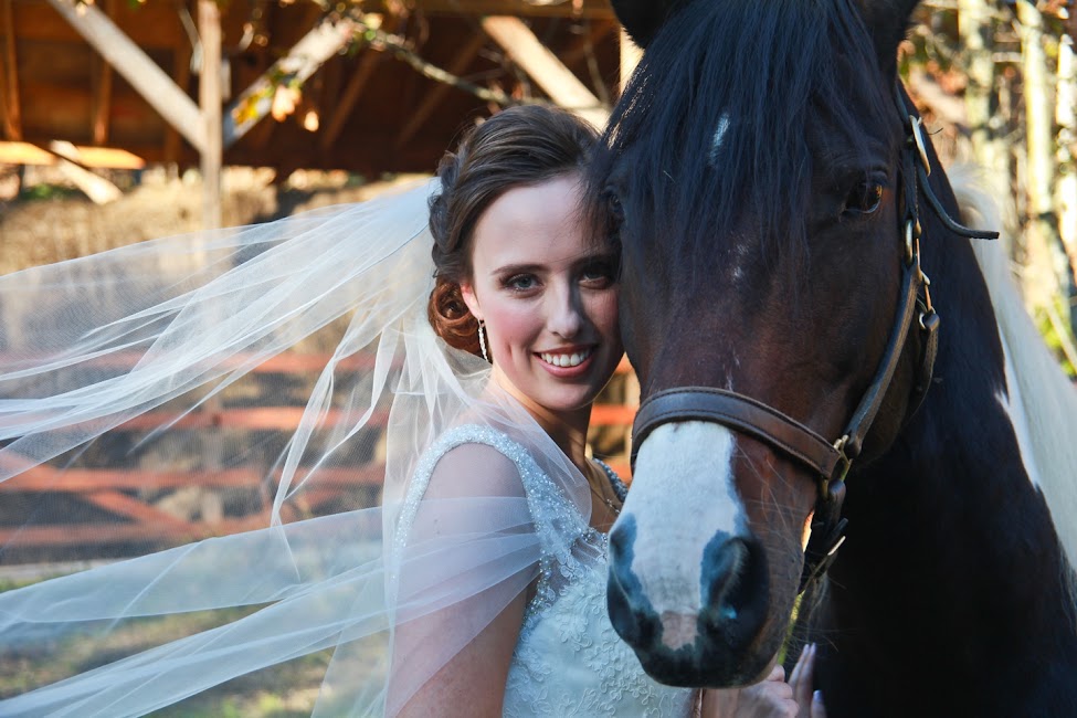 Bride standing beside a horse at The Off Grid Ark during a wedding day photo