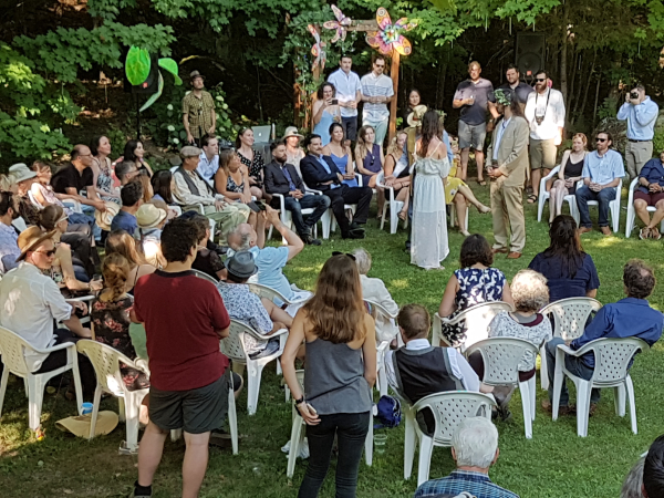Outdoor wedding ceremony with guests gathered in a forest clearing