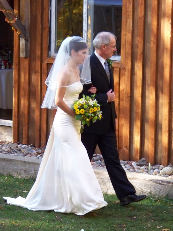 Bride being escorted by her father toward the ceremony at The Off Grid Ark outdoor wedding venue near Ottawa–Gatineau.