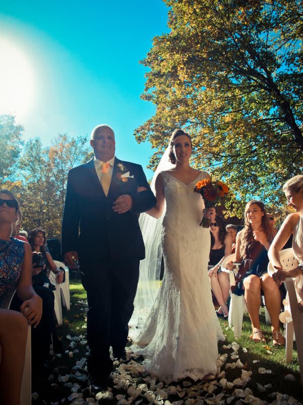 Bride walking down the aisle with her father during an outdoor wedding ceremony at The Off Grid Ark near Ottawa–Gatineau.