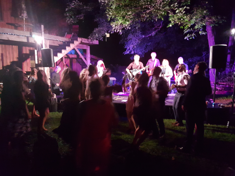 Outdoor wedding reception with a live band performing under string lights at The Off Grid Ark near Ottawa–Gatineau.