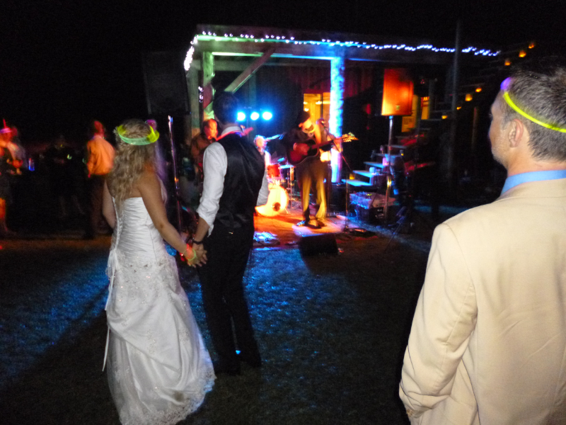 Bride and groom watching a live band during an outdoor nighttime wedding reception at The Off Grid Ark near Ottawa–Gatineau.
