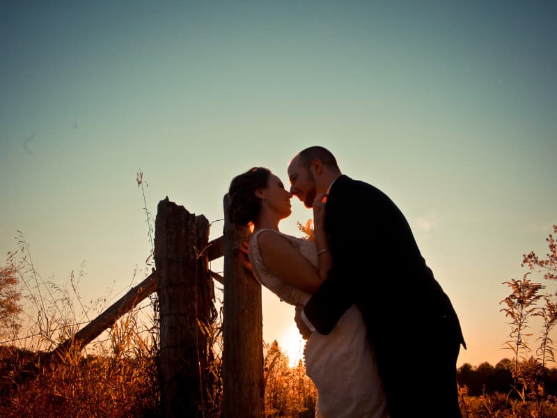 Bride and groom sharing a kiss at sunset during an outdoor wedding photo session at The Off Grid Ark in Western Quebec, near Ottawa–Gatineau.
