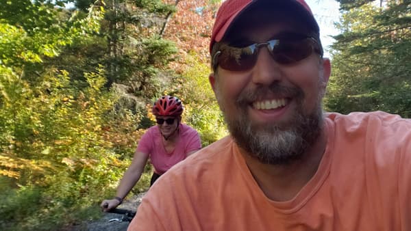 Mike Caldwell and his wife, Monique, cycling together on a forest trail at The Ark.