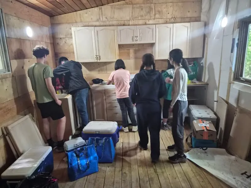 Youth preparing a meal inside the new 12'x36' indoor shelter.