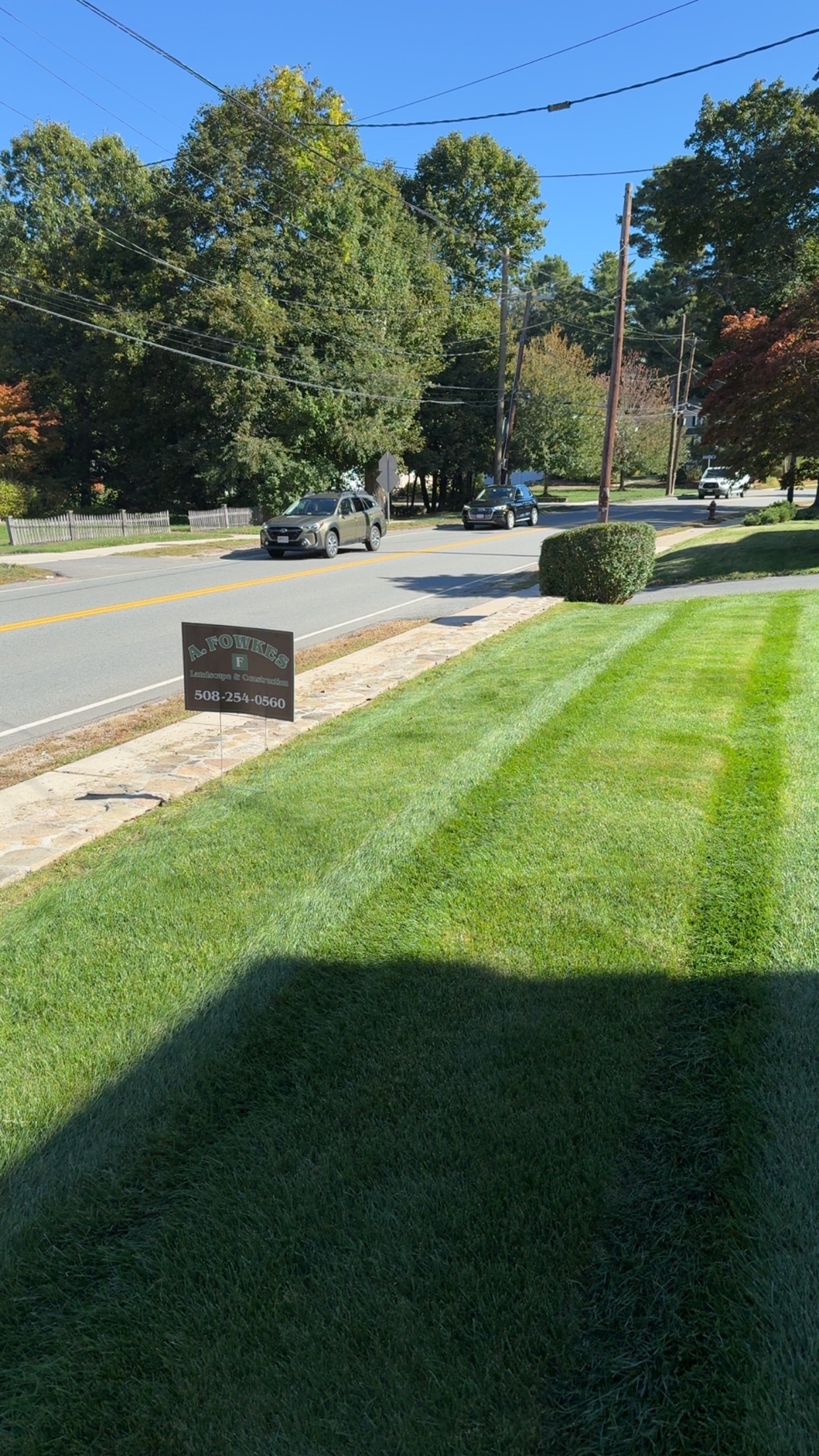 Residential lawn care with professional striping and A. Fowkes Landscape & Construction yard sign