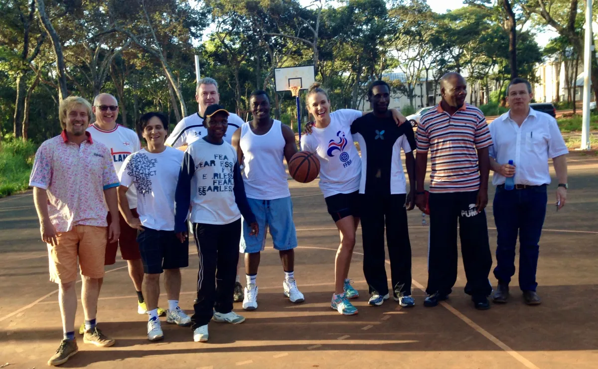 Ana Reed and her team huddled together on a basketball court, holding a basketball: Team Values