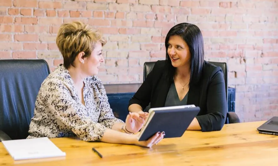 Image of two professional women in conversation about Executive Coaching