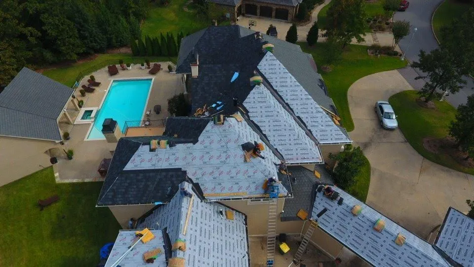 Certified roof installation by Roofing Redefined shown from drone overview with 5-year warranty coverage.
