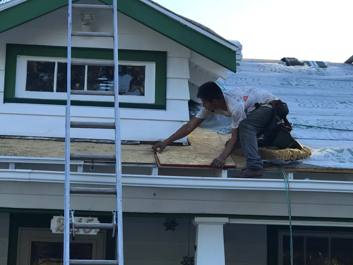 Professional roofer assisting homeowner with insurance claim roof repair in Little Rock, AR."