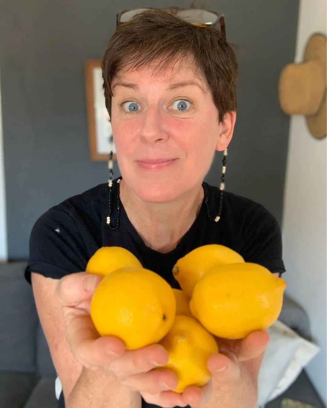 Coach Helen Bennett, food freedom coach, holding a pile of lemons.