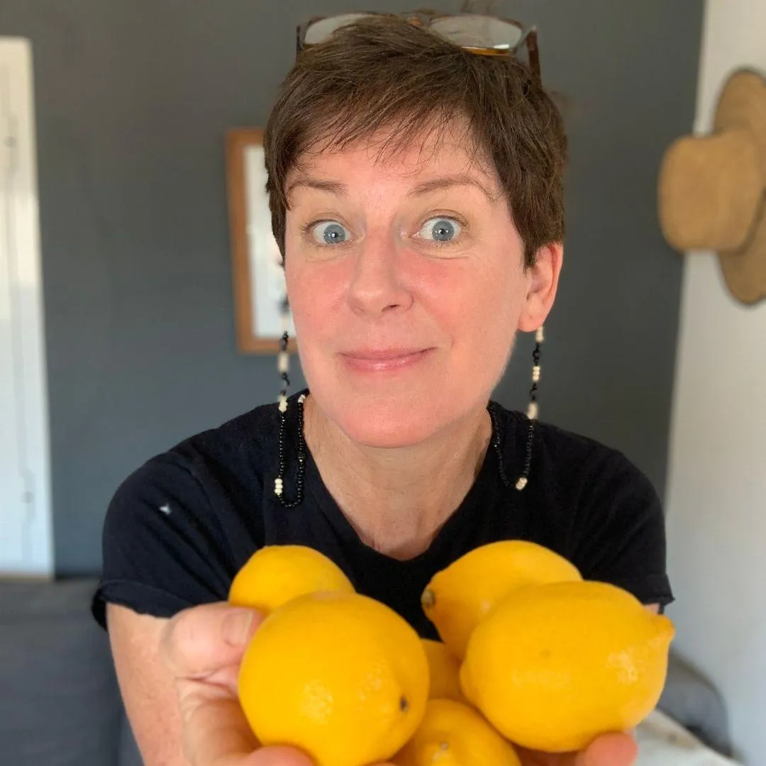 Coach Helen Bennett, food freedom coach, holding a pile of lemons.