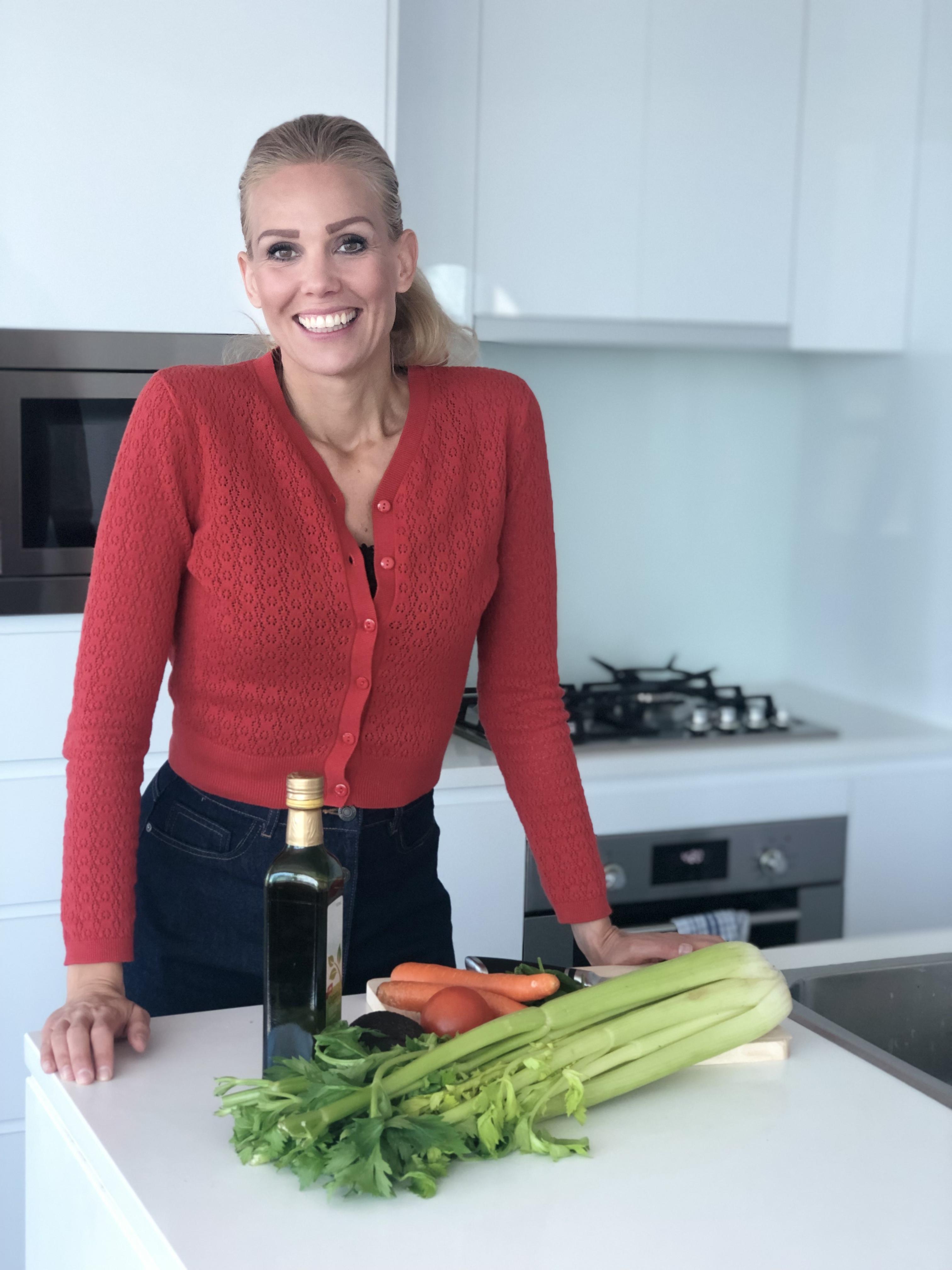 Porträtt av Johanna Bjurström står i köket och lagar hälsosam mat