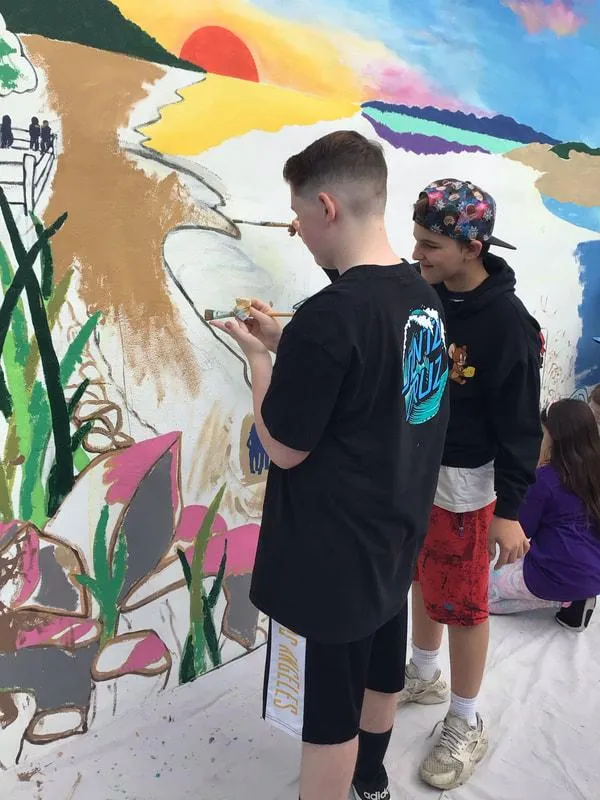 Youth painting nature-inspired wall mural