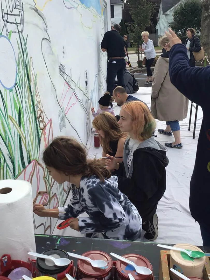Volunteers painting a community mural