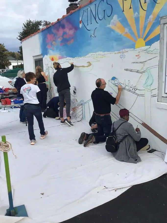 Artists collaborating on outdoor mural