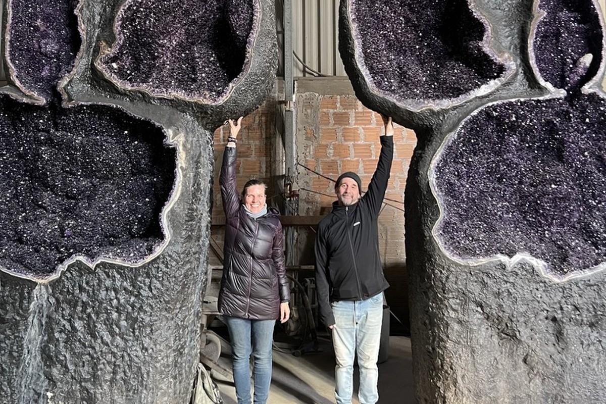 Lisa and Diego standing beneath giant amethyst geodes in Uruguay