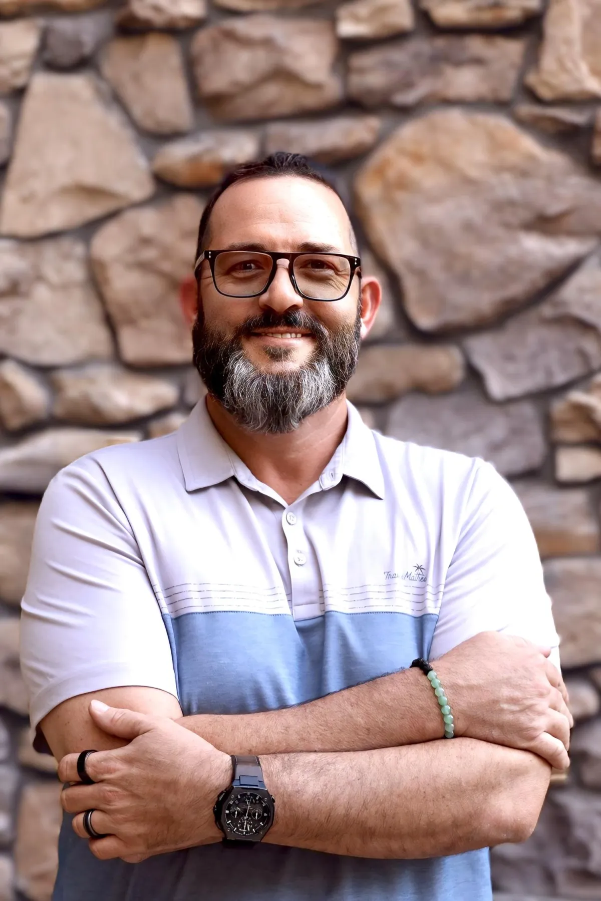 Greg Sarlo, Founder and CEO, professional headshot smiling in a light blue blazer and white shirt.