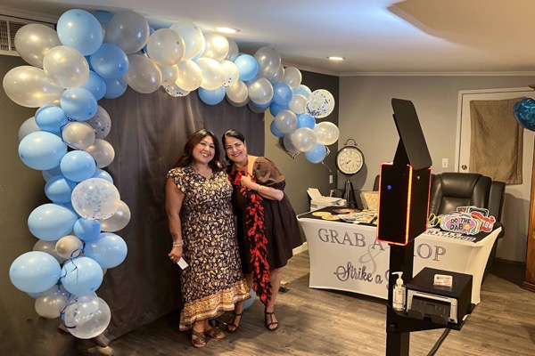 Guests posing beside Capture Entertainment's photo booth at a Southern California celebration