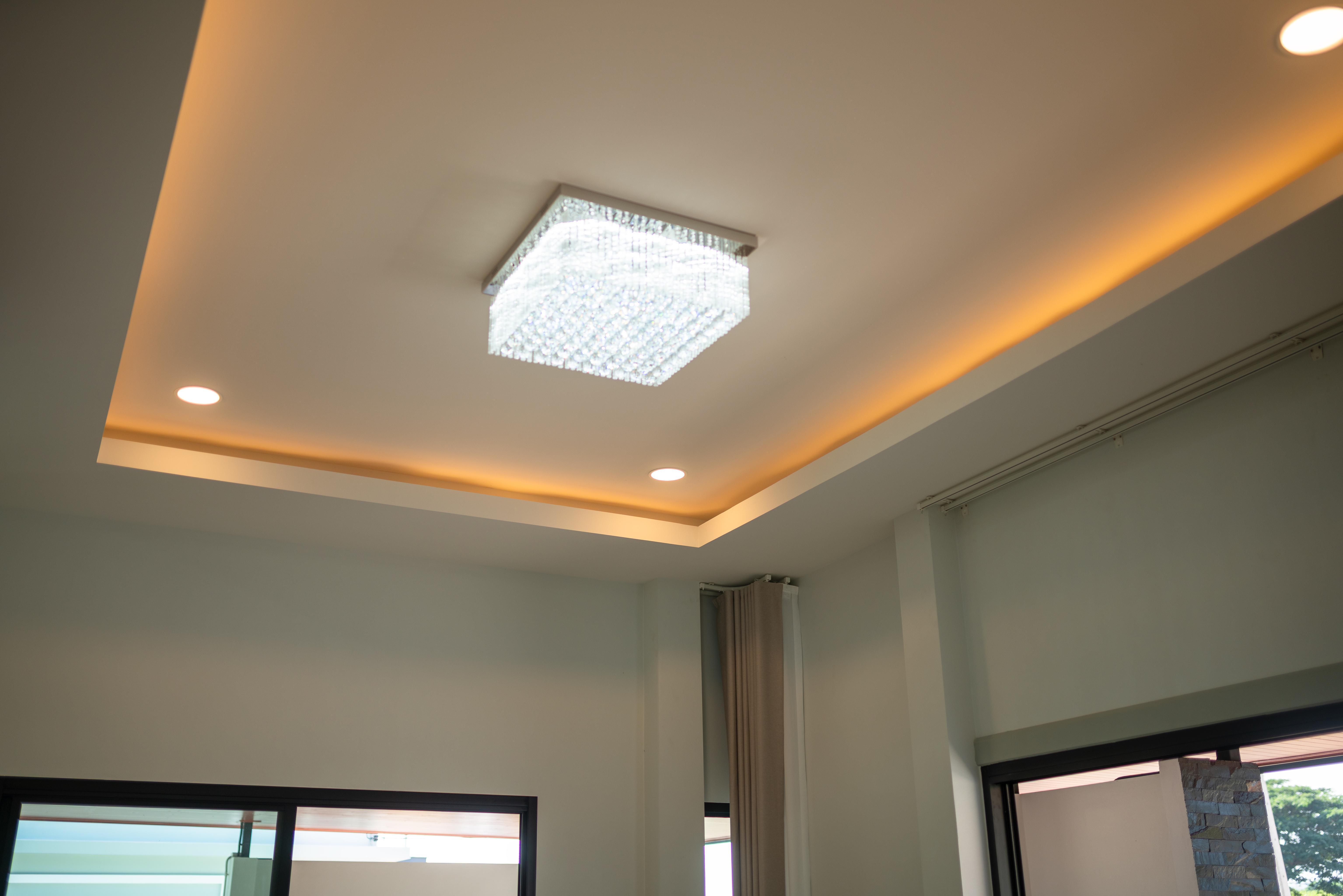 Modern tray ceiling with recessed lighting and crystal LED ceiling light in contemporary living space.