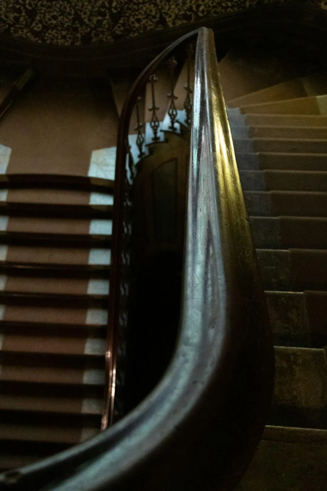 Curved staircase handrail and carpeted steps in historic or luxury interior staircase