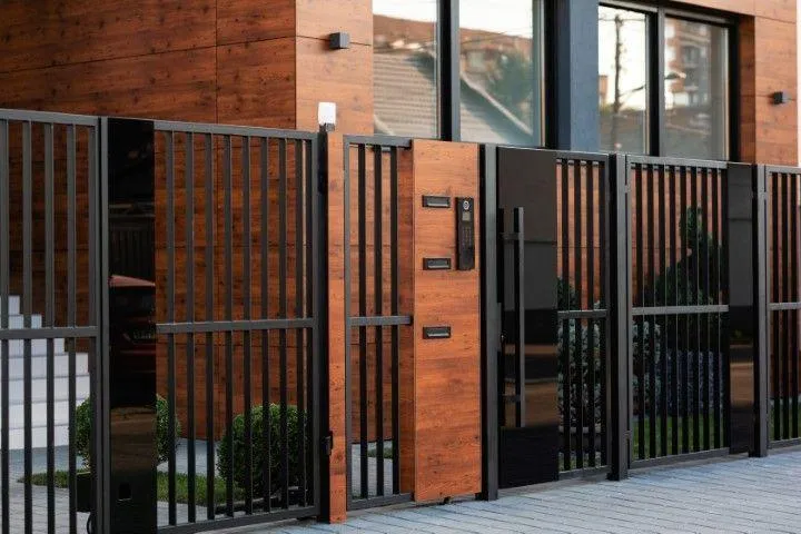 A modern black metal and wood-accented security gate installed by an expert Fencing Contractor in Galt CA.