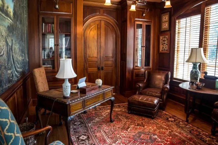 Elegant home office showcasing Custom Carpentry Creations in Clovis with rich wood paneling, built-in bookcases, and a desk.