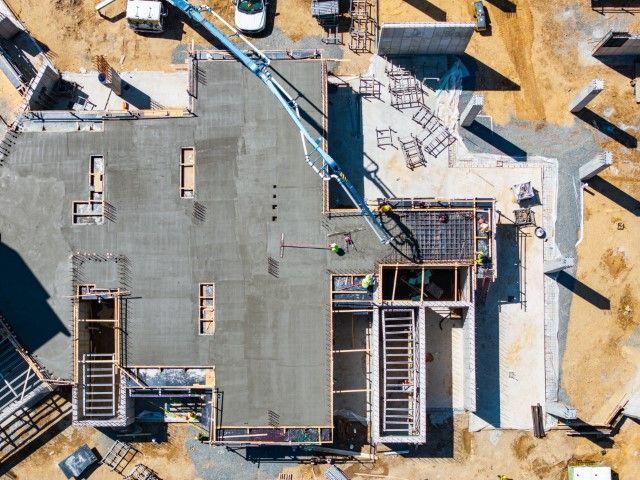Aerial view of a concrete contractor in Dania Beach FL pouring a building foundation with a boom pump.