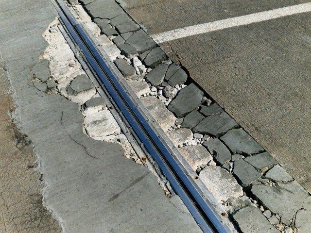 Severe structural damage requiring a concrete contractor in Dania Beach FL to repair cracked slabs and metal expansion joints.