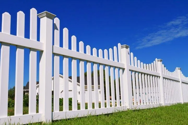 A clean white picket fence set against a blue sky, installed by a professional Fencing Contractor in Exeter PA.