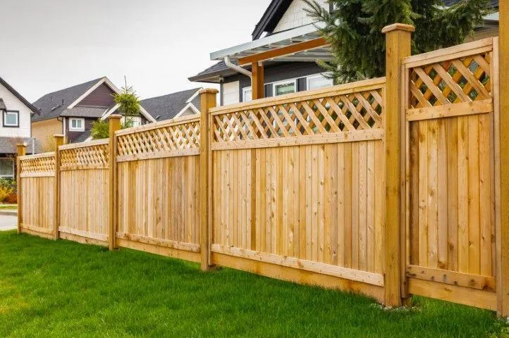 A tall wooden privacy fence featuring a lattice top design, built by a Fencing Contractor in Exeter PA