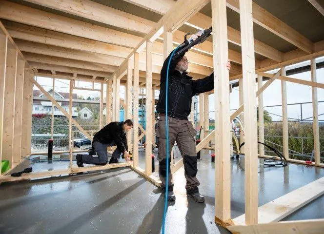 Carpenters build a wood-framed structure, reflecting the expert craftsmanship of Fort Washington Carpentry Craftsmen.